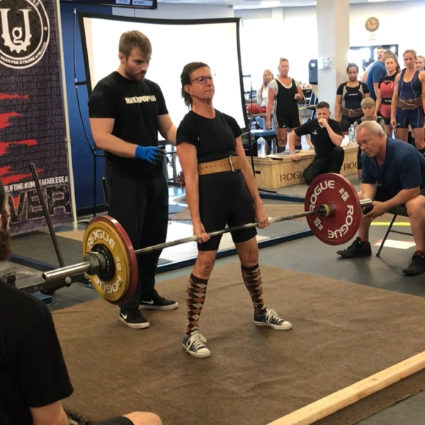 Powerlifter completing a deadlift on the competition platform