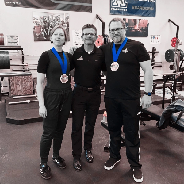 The Protocol powerlifting team wearing competition medals